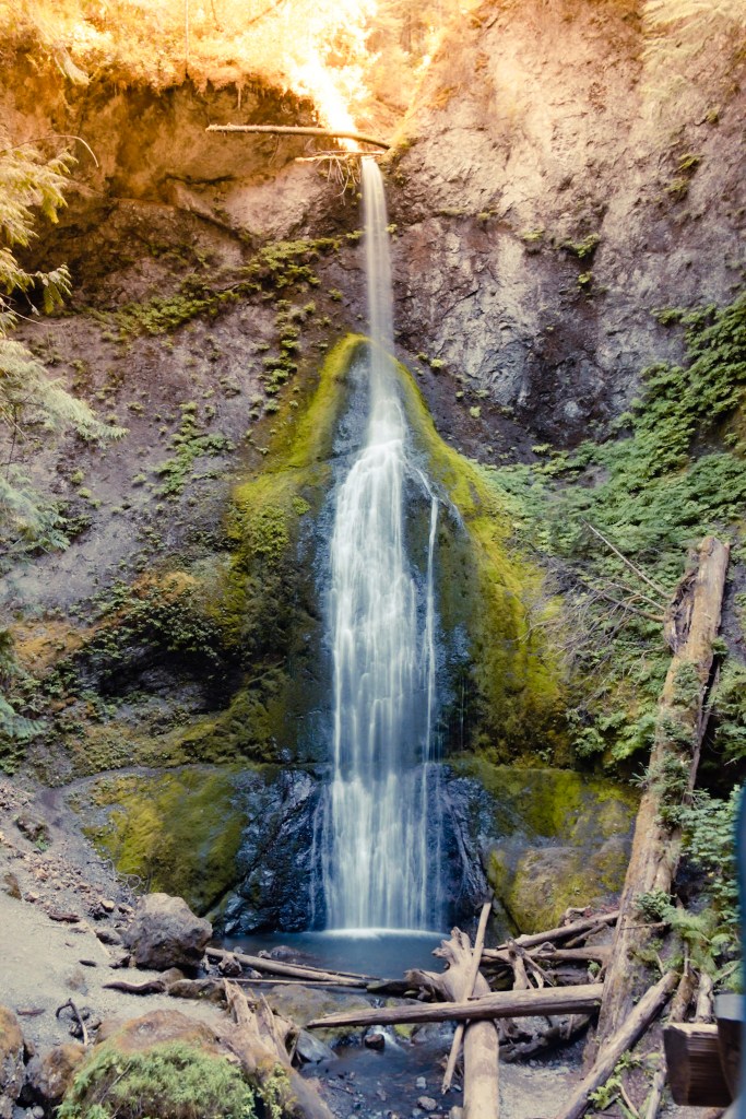A vertical slow-capture view of Marymere Falls, with water softly cascading down moss-covered rock. Someone got a little artsy with the color treatment. 