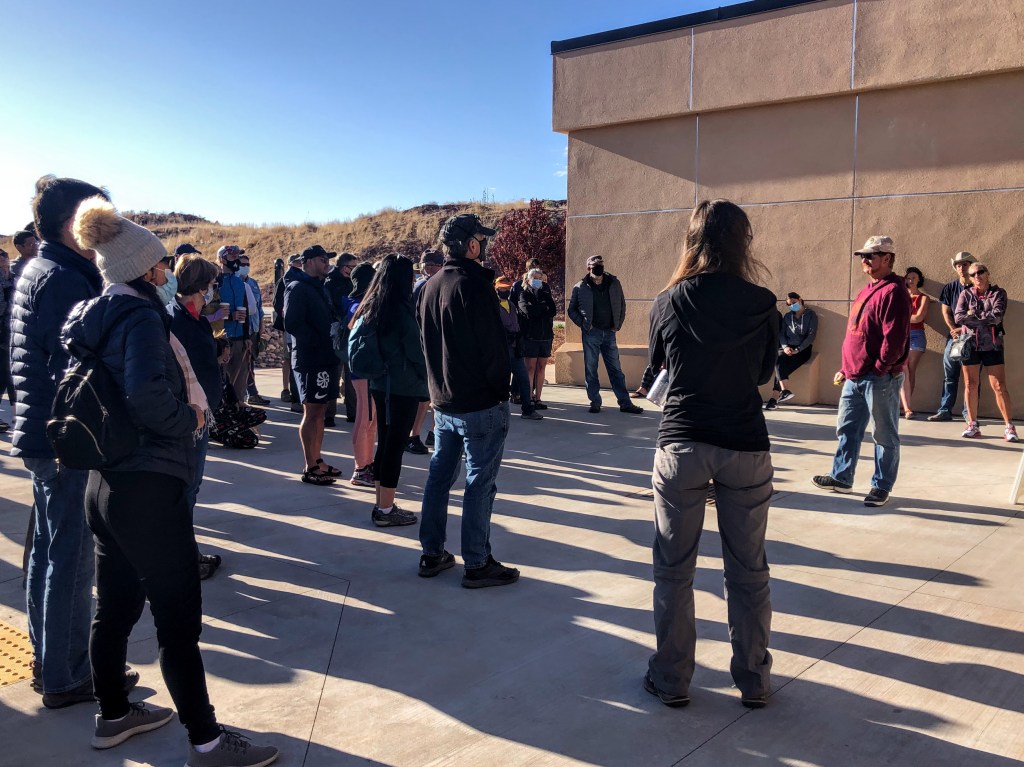 A crowd of people wearing puffy coats, hiking pants, and face masks mills around outside a sand-colored building while a man in a red hoodie and baseball cap speaks. 

Have I mentioned how unimpressed I was with the BLM staff in Kanab? I haven't. I'm thinking about writing up a blog post about it. Not the first time I've interacted with BLM guys. They're super nice, but they kinda seem like the NPS's perpetually high older brother that still lives in Mom's basement and works at McDonald's. 