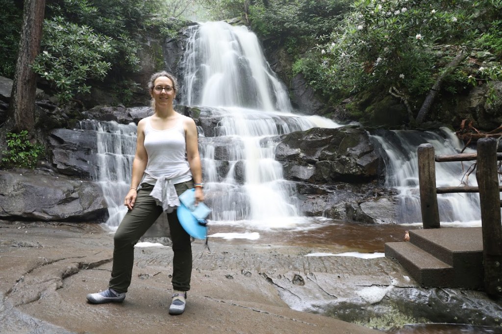 Laura stands in front of a waterfall. 