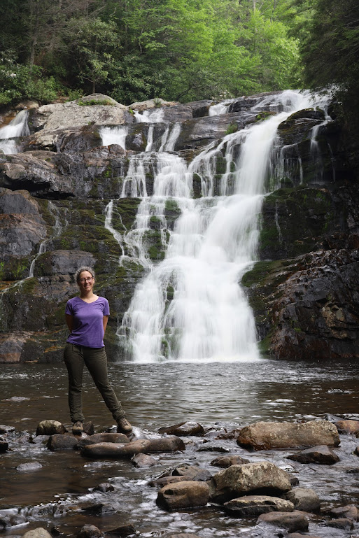 Laura, in the bottom left of the photo, stands on some rocks in the middle of the water with Laurel Falls cascading close behind her.