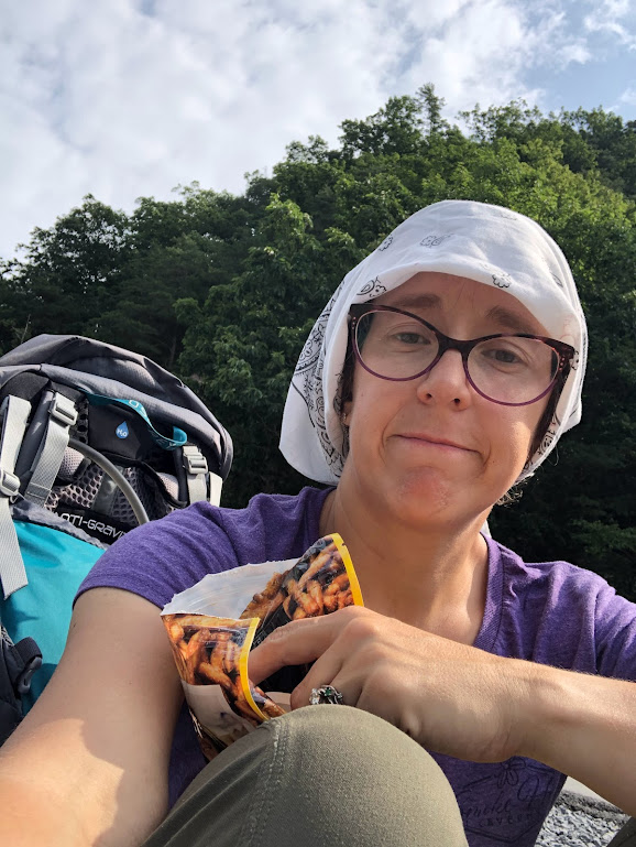 A selfie of Laura, holding a bag of Dot's pretzels and looking a little tattered and tired.