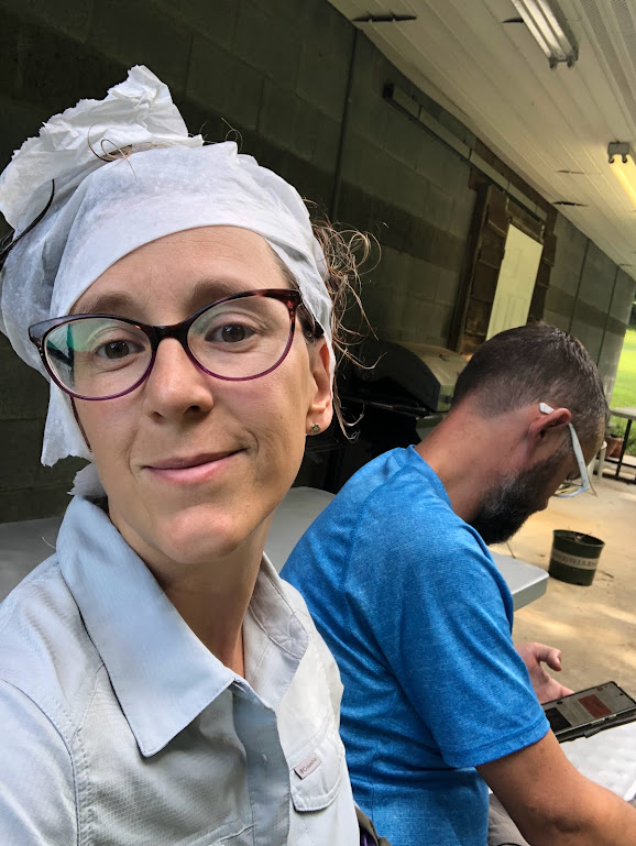 A selfie of Laura, to the left, with Dustin visible to the right in the background. Laura's hair is wrapped in paper towels, a few wet curls sticking out. She looks pleased.