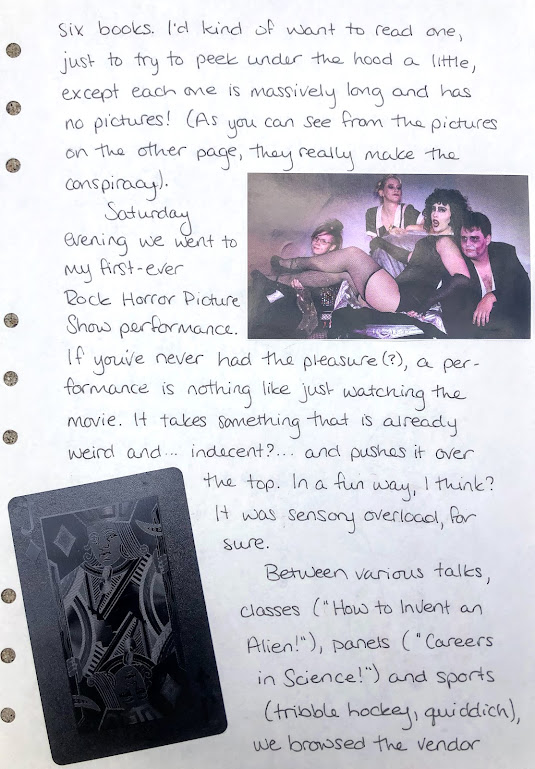 A photograph of a hand-written journal page. The handwriting is in black ink. A photo of the cast of The Rocky Horror Picture Show is pasted in the upper right, and a black playing card in the lower left.