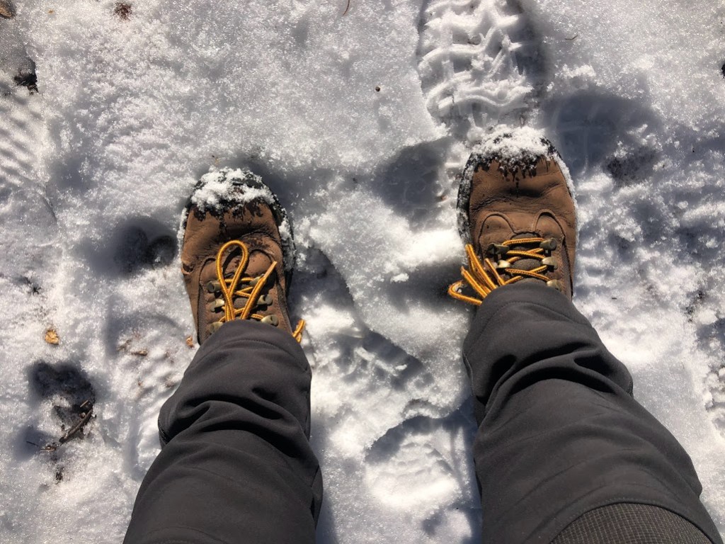 A close-up photo of Laura's boots as she stands in barely any snow. The toes of the boots are wet and somehow covered in snow despite its lack of depth.